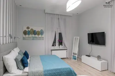 a bedroom with a bed and a flat screen tv at Mateyko Apartment in Kraków