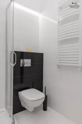 a bathroom with a toilet and a glass shower at Mateyko Apartment in Kraków
