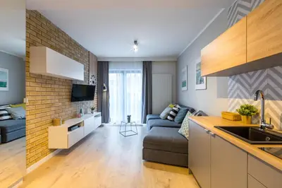 a kitchen and a living room with a couch at Friendhouse Apartments Vistula&Wawel in Kraków