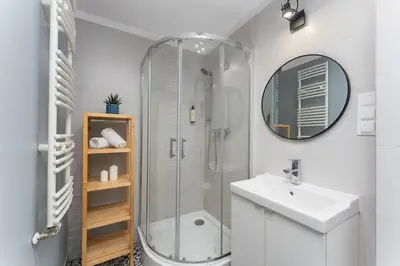 a bedroom with a bed and a chair at Friendhouse Apartments Vistula&Wawel in Kraków