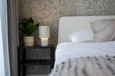 a bedroom with a bed and a chair and a window at Friendhouse Apartments Vistula&Wawel in Kraków
