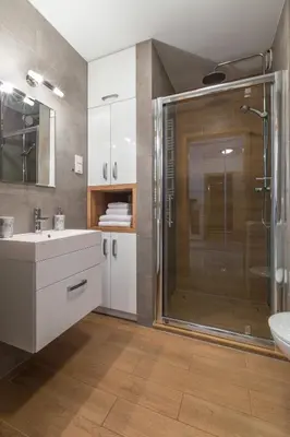 a bathroom with a glass shower and a sink at Friendhouse Apartments Vistula&Wawel in Kraków