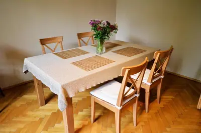 a dining room table with a vase of flowers on it at Apartament Krych in Rabka