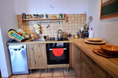 a kitchen with a stove with a red towel on the oven at Apartament Krych in Rabka
