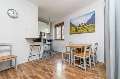 a kitchen and dining room with a table and chairs at Landmark Apartments in Kraków