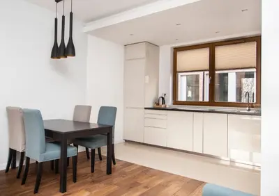a kitchen with a dining room table and chairs at Landmark Apartments in Kraków