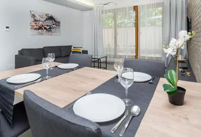a dining room with a table with white plates on it at Landmark Apartments in Kraków