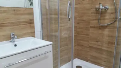 a shower with a glass door next to a sink at Willa Ostoja in Rabka