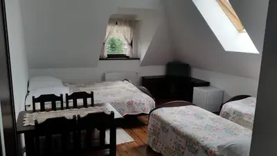 a attic room with two beds and a window at Willa Ostoja in Rabka