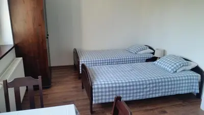 a room with two beds and a table at Willa Ostoja in Rabka