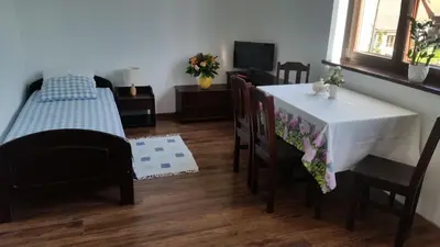 a dining room with a table and chairs and a television at Willa Ostoja in Rabka