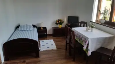 a room with a table and a bed and a table and chairs at Willa Ostoja in Rabka