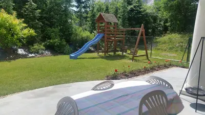 a backyard with a playground with a slide and a table at Willa Ostoja in Rabka
