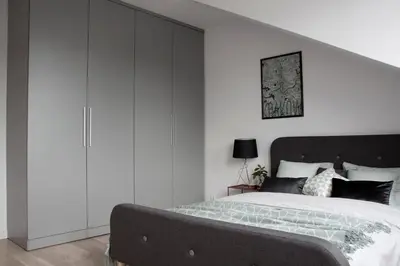 a bedroom with a large bed with white cabinets at Cracovia in Kraków