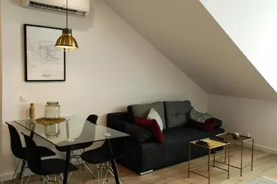 a living room with a black couch and a table at Cracovia in Kraków