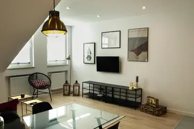 a living room with a glass table and a tv at Cracovia in Kraków