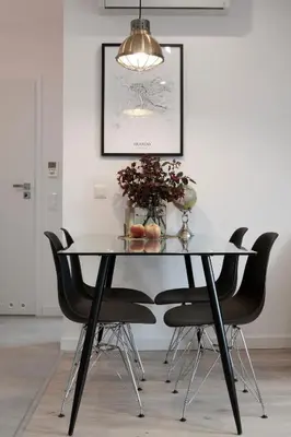a dining room table with black chairs and a light fixture at Cracovia in Kraków