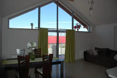 a living room with a table and a large window at Pokoje Bakos Radocza in Radocza