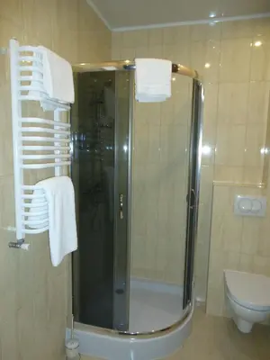 a bathroom with a shower and a toilet and towels at Pokoje Bakos Radocza in Radocza