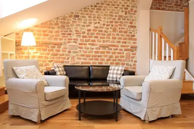 a living room with two chairs and a couch at Gołębia 8 Residence in Kraków