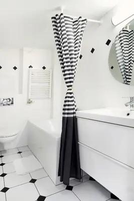 a bathroom with a black and white shower curtain at Gołębia 8 Residence in Kraków