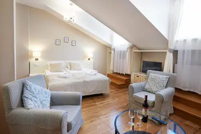 a living room with a bed and two chairs and a table at Gołębia 8 Residence in Kraków