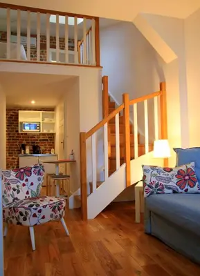 a living room with a staircase and a couch and a chair at Gołębia 8 Residence in Kraków