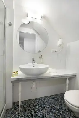 a bathroom with a sink and a mirror and a toilet at Gołębia 8 Residence in Kraków