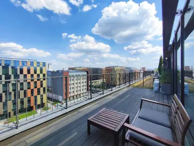 a balcony with a bench and a view of a city at Turnau City Aparthotel in Kraków