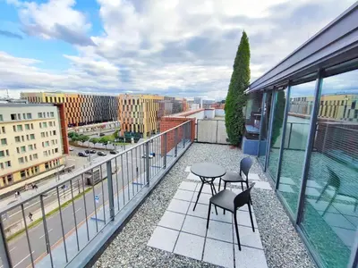 a balcony with two chairs and a table on a building at Turnau City Aparthotel in Kraków
