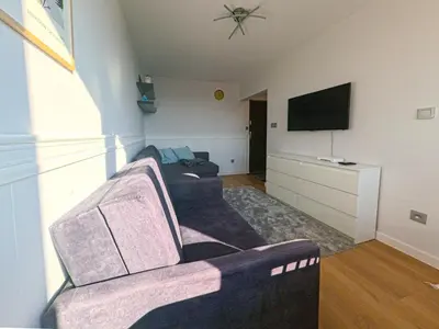 a living room with a couch and a flat screen tv at Apartament Parkowy Rabka in Rabka