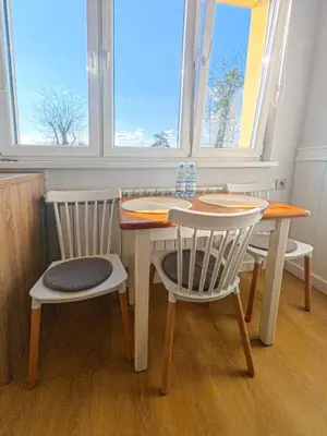 a table and two chairs with a table and two windows at Apartament Parkowy Rabka in Rabka