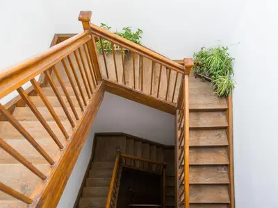 a wooden staircase with wooden railings and potted plants at Nicholas Studio in Kraków