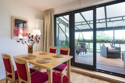 a dining room with a wooden table and chairs at Kazimierz Apartment in Kraków
