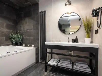 a bathroom with a sink and a tub and a mirror at Jacuzzi Apartments in Kraków