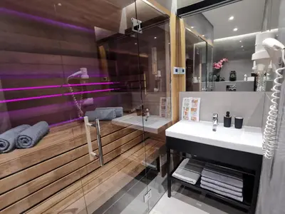 a bathroom with a sink and a shower at Jacuzzi Apartments in Kraków