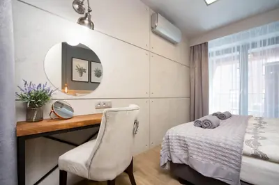 a bedroom with a desk and a mirror and a bed at Jacuzzi Apartments in Kraków