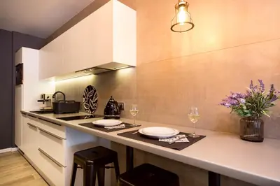 a kitchen with a counter with plates and wine glasses at Jacuzzi Apartments in Kraków