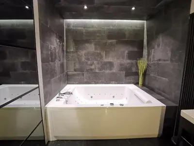 a large bath tub in a bathroom next to a bath tub at Jacuzzi Apartments in Kraków