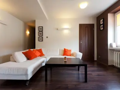 a living room with a white couch and a coffee table at Irish Apartment in Kraków