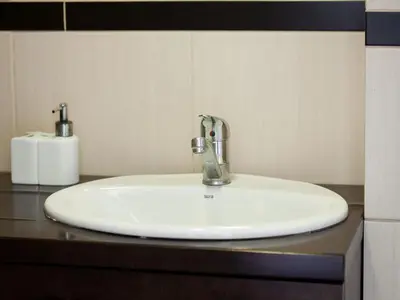 a bathroom sink with a faucet on a counter at Irish Apartment in Kraków