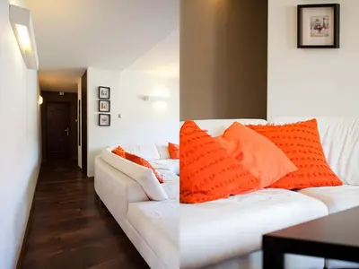 a living room with a white couch with orange pillows at Irish Apartment in Kraków