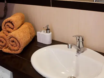 a bathroom with a sink and towels on a counter at Irish Apartment in Kraków