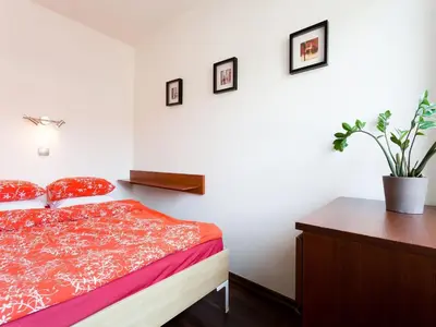 a bedroom with a bed and a table and a plant at Irish Apartment in Kraków
