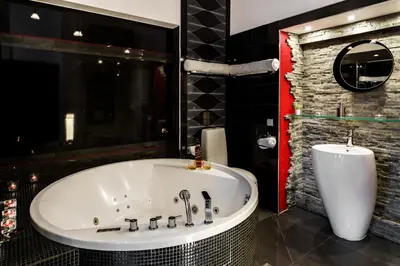a bathroom with a large tub and a mirror at Komorowski Luxury Guest Rooms in Kraków