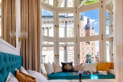 a living room with a couch in front of a large window at Feniks Fragola Apartments in Kraków
