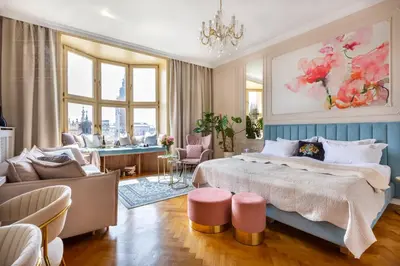 a bedroom with a large bed and a living room at Feniks Fragola Apartments in Kraków