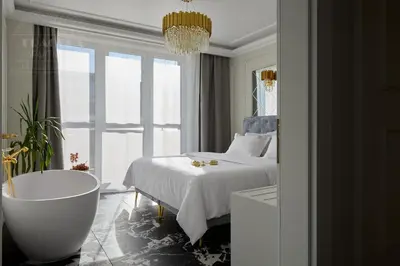 a bedroom with a tub and a bed and a window at Feniks Fragola Apartments in Kraków