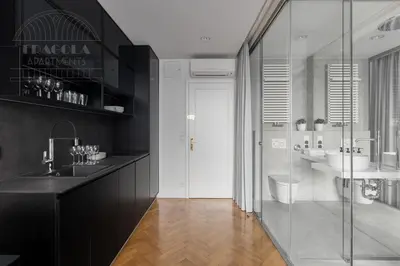 a bathroom with two sinks and a glass shower at Feniks Fragola Apartments in Kraków