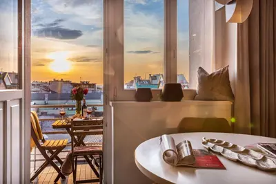 a room with a view of a balcony with a table at Feniks Fragola Apartments in Kraków
